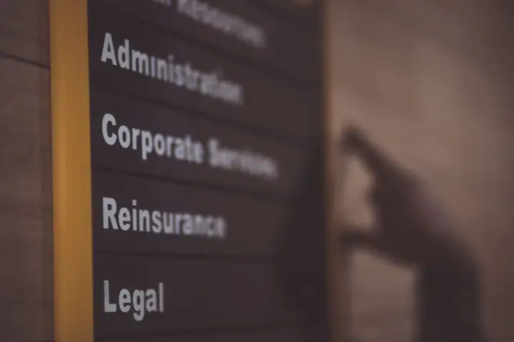 An office directory sign lists departments, including Administration, Corporate Services and Legal.