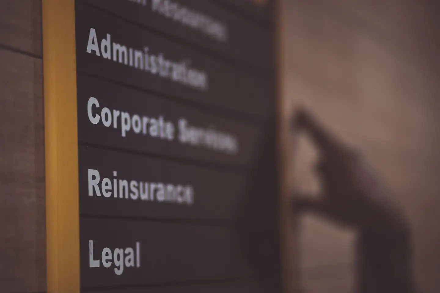 An office directory sign lists departments, including Administration, Corporate Services and Legal.